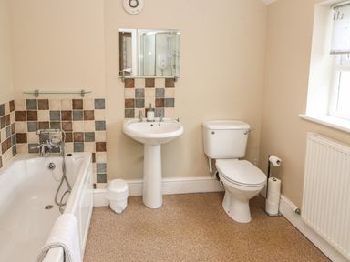 A bathroom with a bathtub sink and toilet at Bay Tree Cottage Keswick