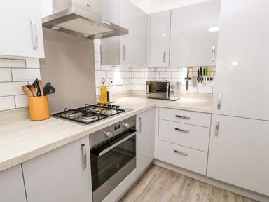 A kitchen with a gas stove oven microwave knives and wooden utensils at 20 Bishops Way in Falmouth