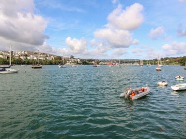 A body of water with multiple sailboats and small boats near a town at 20 Bishops Way in Falmouth