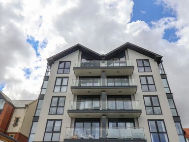 The exterior of a modern multi-story building with glass balconies and large windows at The Penthouse in Scarborough