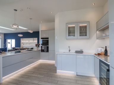 A modern kitchen with white cabinets and built in appliances with under cabinet lighting at The Penthouse in Scarborough