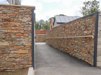 A stone walled outdoor walkway with a metal handrail at The Penthouse in Scarborough