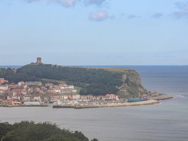 A coastal town with a harbor and an old castle on a hill by the sea at The Penthouse in Scarborough