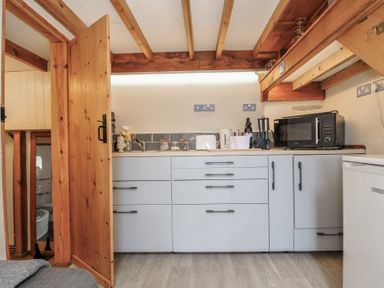 A kitchen with a sink and cabinets at Little Coombe in Trehunist near Liskeard