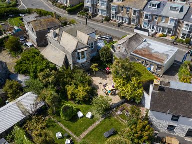 An aerial view of houses and a garden with trees and outdoor furniture at Ayr Farmhouse in St Ives