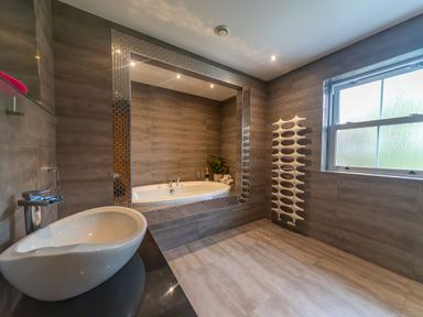 A bathroom with a sink a bathtub a window and a radiator at Parc Y Deri in Rhos-y-garth near Aberystwyth