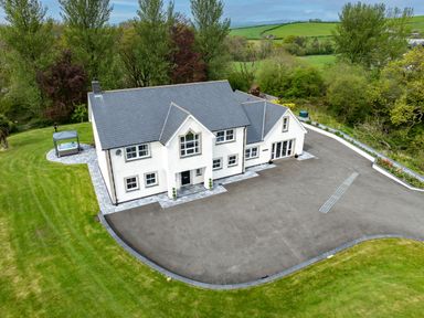 A large white two-story house with a gray roof surrounded by a paved driveway and green grass at Parc Y Deri in Rhos-y-garth near Aberystwyth
