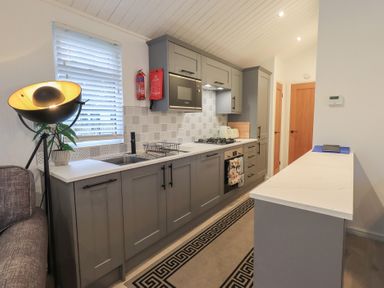 A kitchen with modern cabinets and appliances at Merewood in Troutbeck Bridge