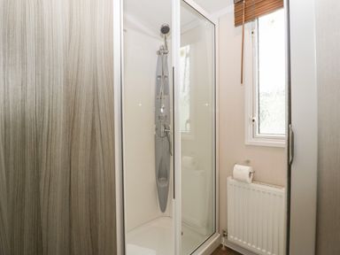 A bathroom with a shower cubicle radiator and a window at Swan in Shobdon