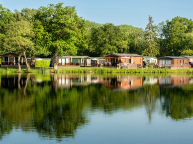 A row of caravans beside a pond at Swan in Shobdon