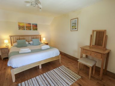 A bedroom with a bed and dressing table at Felin Gogoyan in Tregaron