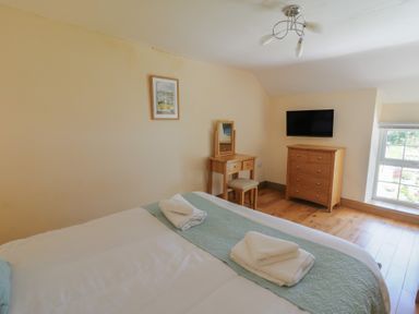 A bedroom with a bed and furniture at Felin Gogoyan Tregaron