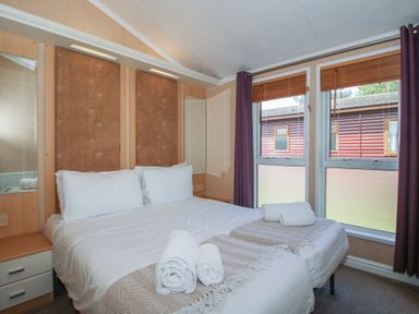 A bedroom with a bed and mirrors at Daisy in Eardisland