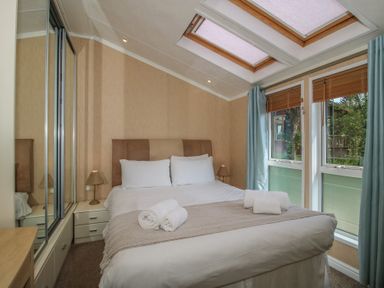 A bedroom with a bed and windows at Daisy in Eardisland