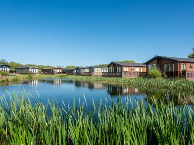 A row of lodges by the water at Daisy in Eardisland