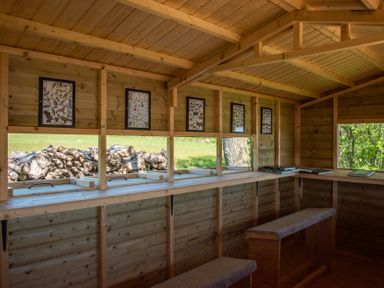An indoor cabin with benches and windows at Daisy in Eardisland