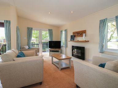 A living room with a sofa and television at Daffodil in Eardisland