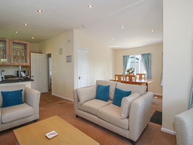 A living room with a sofa and a dining area at Daffodil in Eardisland