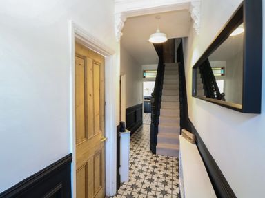 A hallway with a staircase and a door at Sunrise House Pakefield near Lowestoft