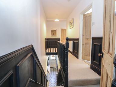 A hallway with staircase and doors at Sunrise House Pakefield near Lowestoft