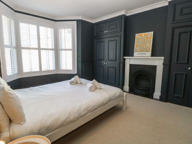 A bedroom with a bed and towels at Sunrise House Pakefield near Lowestoft