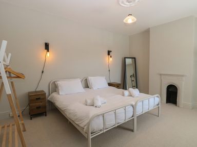 A bedroom with a bed and a mirror at Sunrise House in Pakefield near Lowestoft