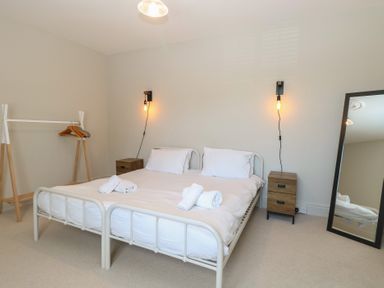 A bedroom with a bed and a clothes rack at Sunrise House in Pakefield near Lowestoft