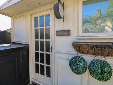 An outdoor entrance with a clock and plants at Sunrise House Pakefield near Lowestoft