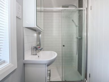 A bathroom with a sink and a glass enclosed shower at Lake View Lodge in Tallington