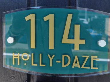 A house number sign with 114 and the name Holly-Daze at 114 Cherry Park in Chapel St Leonards