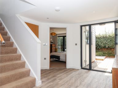 An entryway with carpeted stairs wooden floor a door to a bedroom and glass doors leading outside at Pebble Ridge View in Westward Ho