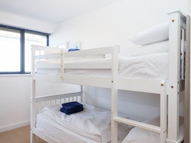 A bedroom with a white bunk bed and folded towels on each bed at Pebble Ridge View in Westward Ho