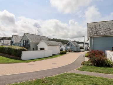 A residential street with modern houses and greenery at Pebble Ridge View in Westward Ho