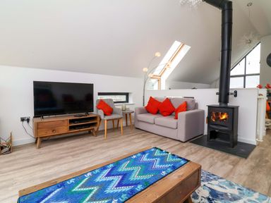 A living room with a television and sofa at Pebble Ridge View in Westward Ho!