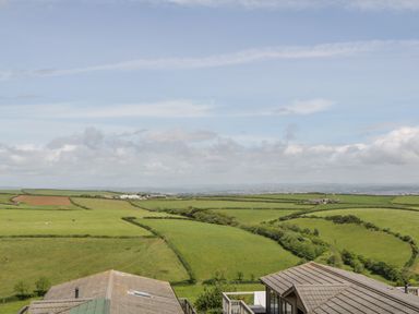 A rural landscape with green fields and farm buildings at Three Views Lodge in Whitsand Bay Fort Holiday Village