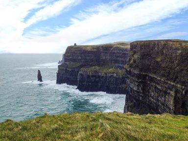 Sea cliffs with rocky formations and grassy tops beside the ocean at Bluebell Cottage in Spanish Point County Clare