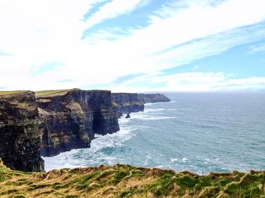 A coastline with high cliffs overlooking the ocean and grassy land at Bluebell Cottage in Spanish Point County Clare
