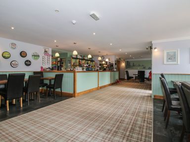 A bar area with tables and chairs at Dove in Shobdon
