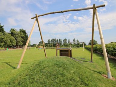 A playground with swings and play structure at Dove in Shobdon