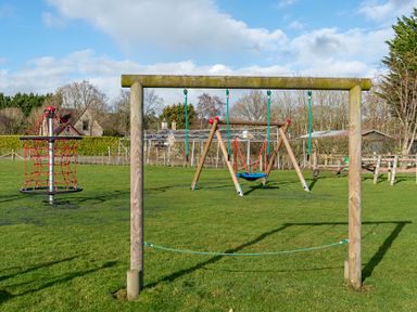 A playground with swings and climbing frame at Dove in Shobdon