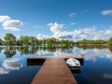 A dock with a boat on a lake at Dove in Shobdon