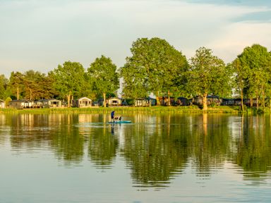 A lake with paddleboarding and holiday homes at Dove in Shobdon