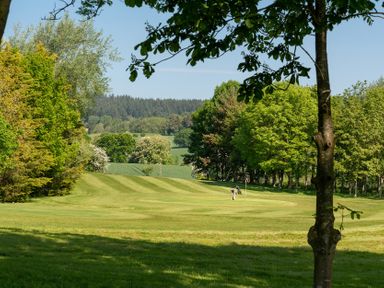 A golf course with a player near a flag at Dove in Shobdon