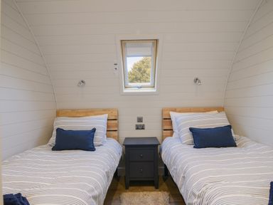 A bedroom with two single beds separated by a nightstand under a skylight window at Cedar in Wootton Fitzpaine near Charmouth