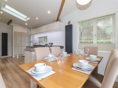 A dining table set with plates and glasses in a kitchen dining area at Serendipity R11 Fallbarrow Park near Bowness-On-Windermere