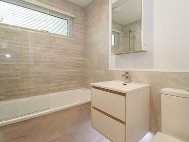 A bathroom with a bathtub shower sink cabinet toilet and a mirror at Serendipity in R11 Fallbarrow Park near Bowness-On-Windermere