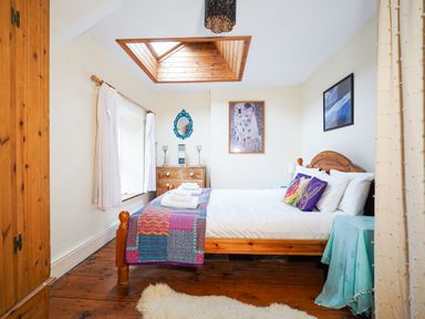 A bedroom with a wooden bed and dresser under a skylight at Delfryn Goginan in Goginan near Aberystwyth