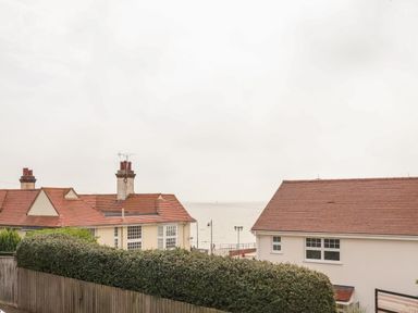 A view of houses with tiled roofs and a hedge overlooking the sea at The Pink House in Felixstowe Suffolk