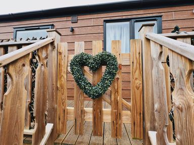A wooden fence gate with a heart-shaped green wreath at Pine Lake View in Coniston View 3 Carnforth
