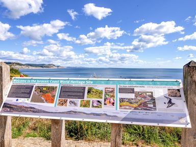 An information board about the Jurassic Coast World Heritage Site with a coastal view in the background at The Hideaway in Eype